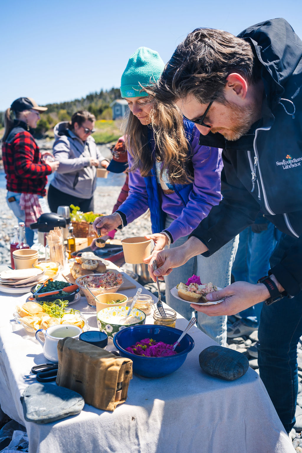 Guests serving themselves food from the table at a Wildera beach boil up